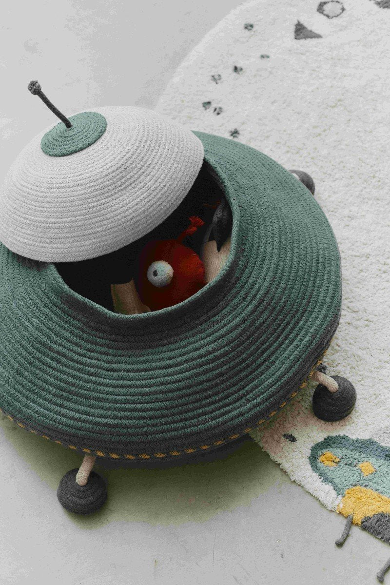 3. Close-up of Lorena Canals UFO basket with red fabric alien inside, placed on a decorative rug