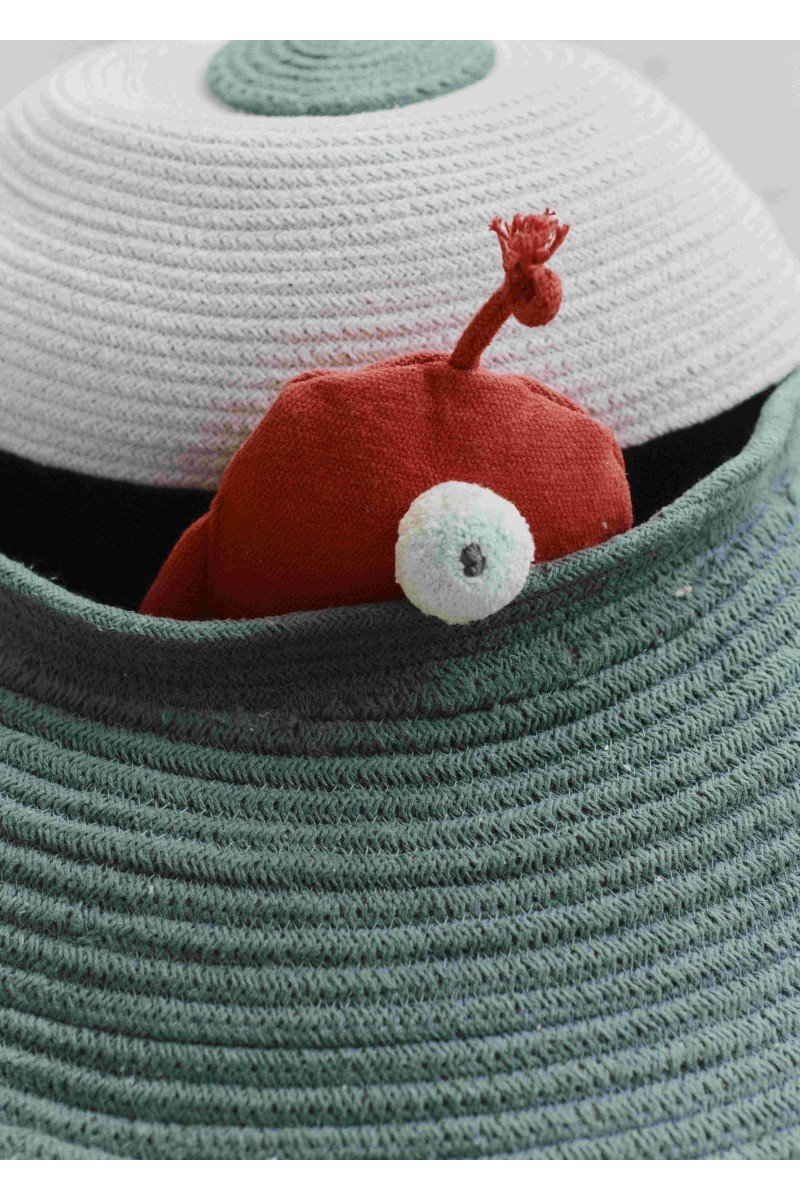 3. Close-up of red fabric alien toy peeking out from green and white UFO basket by Lorena Canals