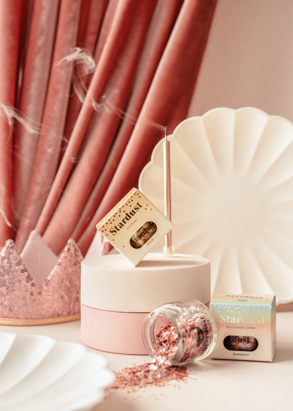 2. Decorative eco glitter gold star dust in a glass jar with packaging, set against a pink and white backdrop with decorative elements