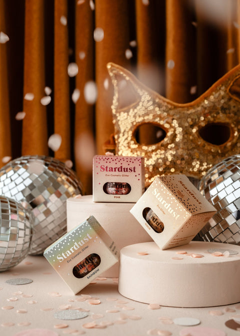 2. Decorative eco glitter gold star dust packaging with disco balls and a gold mask, set against a festive backdrop