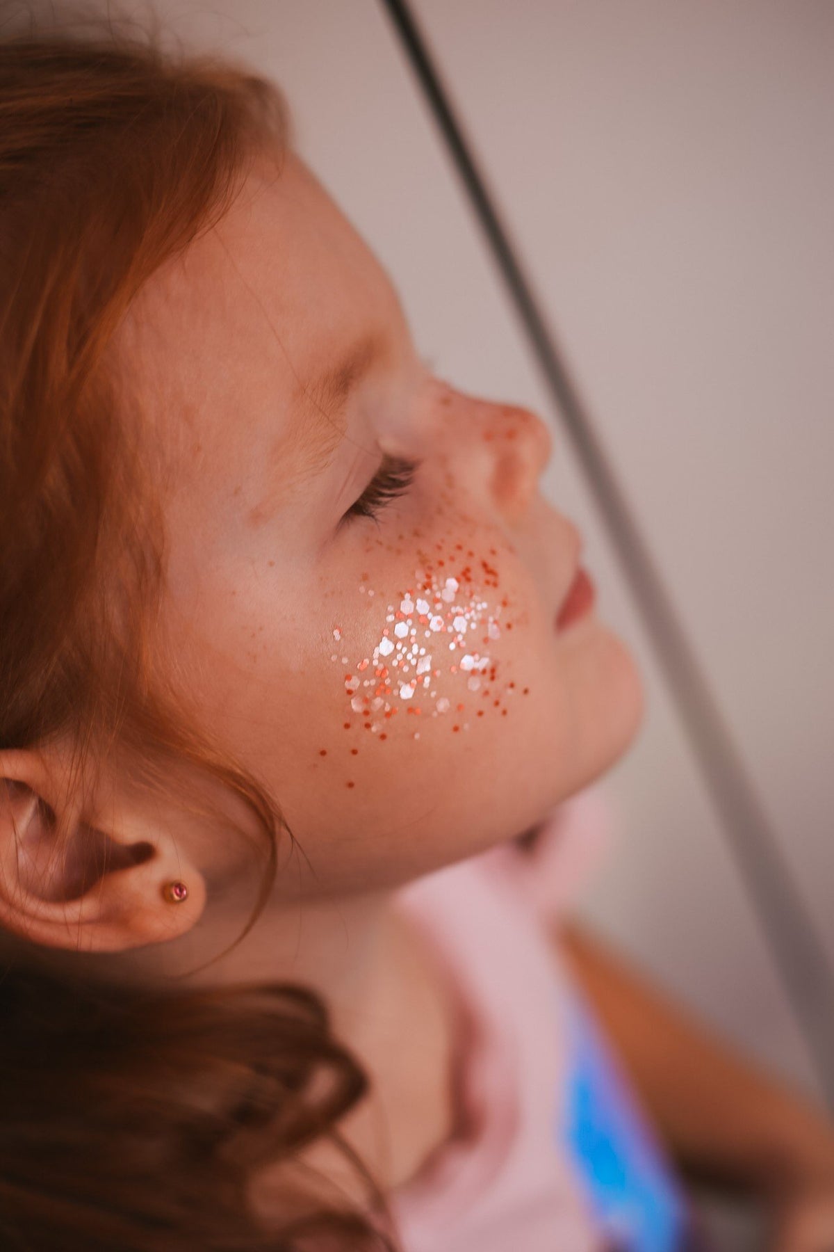 5. Close-up of young girl with pink eco glitter on cheek, eyes closed
