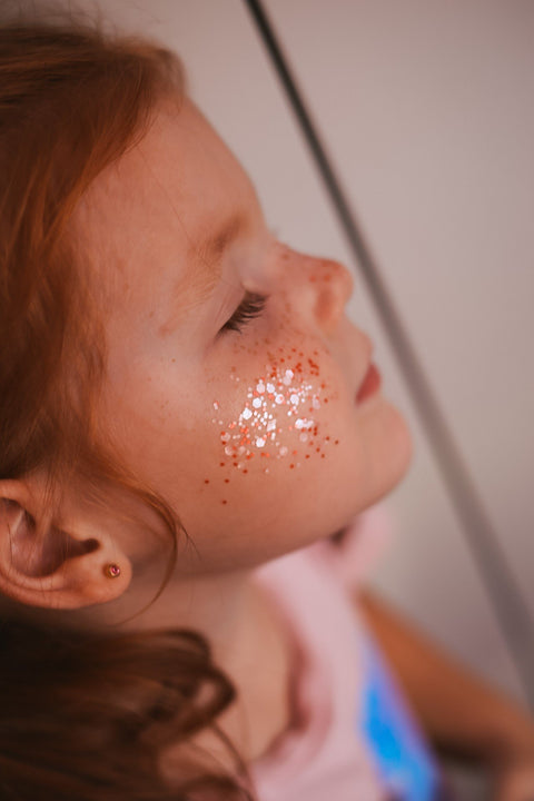 5. Close-up of young girl with pink eco glitter on cheek, eyes closed