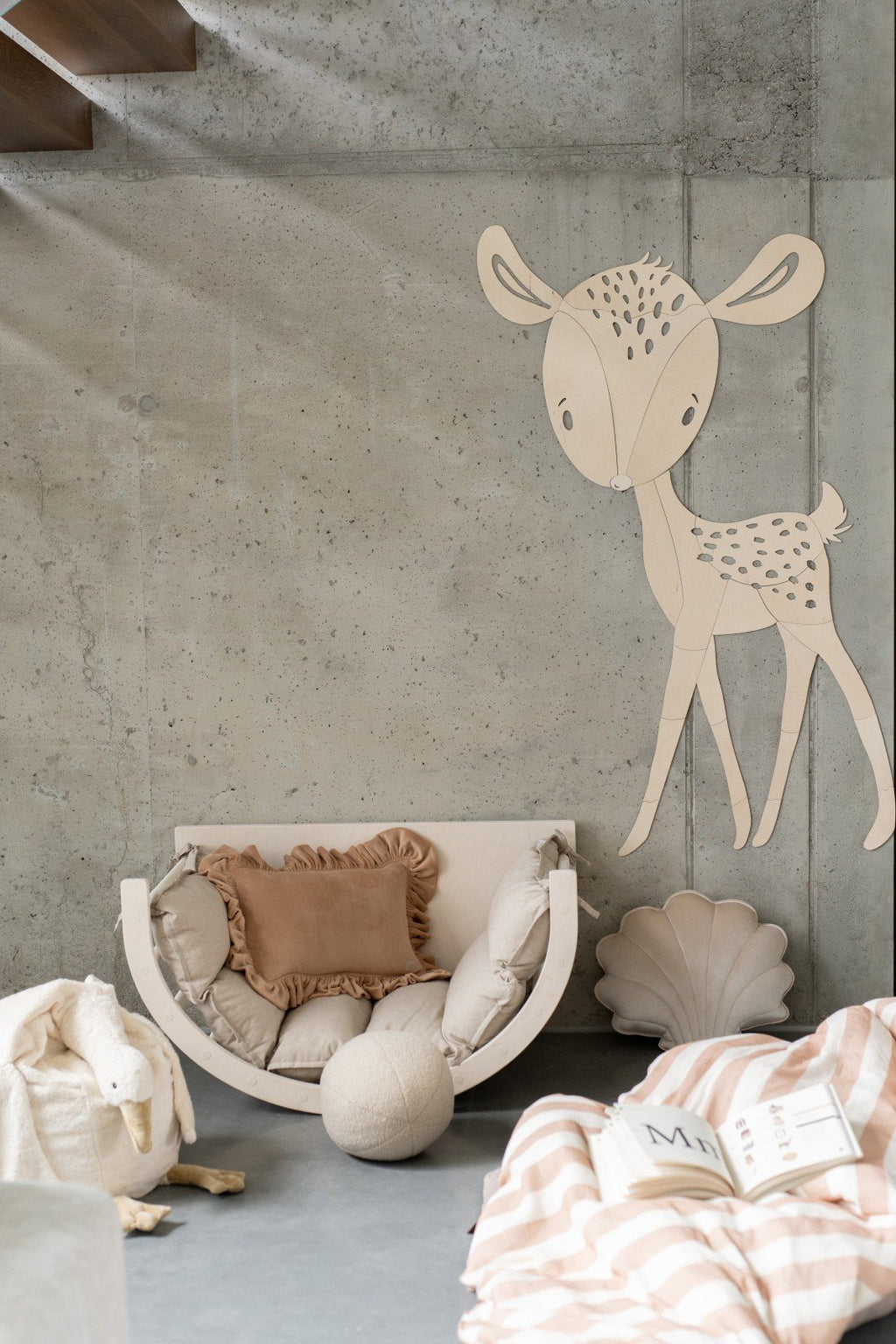 1. Deer wooden wall decoration in child's room with beige and pink decor, featuring a cozy chair and pillows
