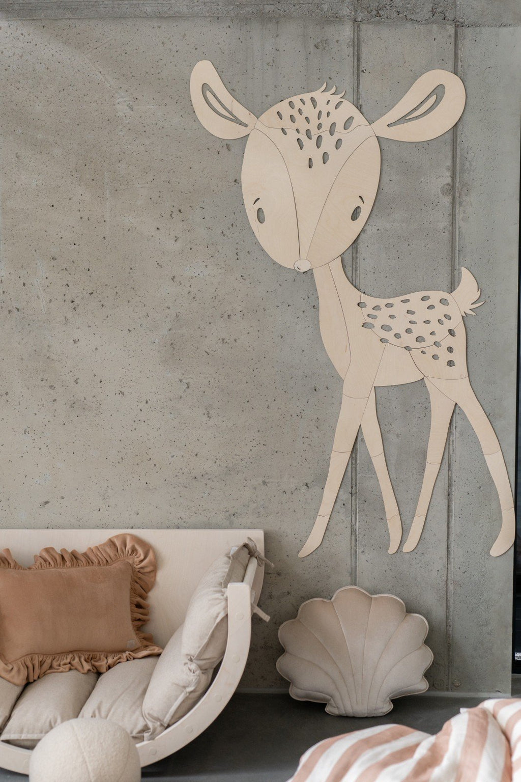 4. Deer wooden wall decoration in nursery setting with beige and pink cushions