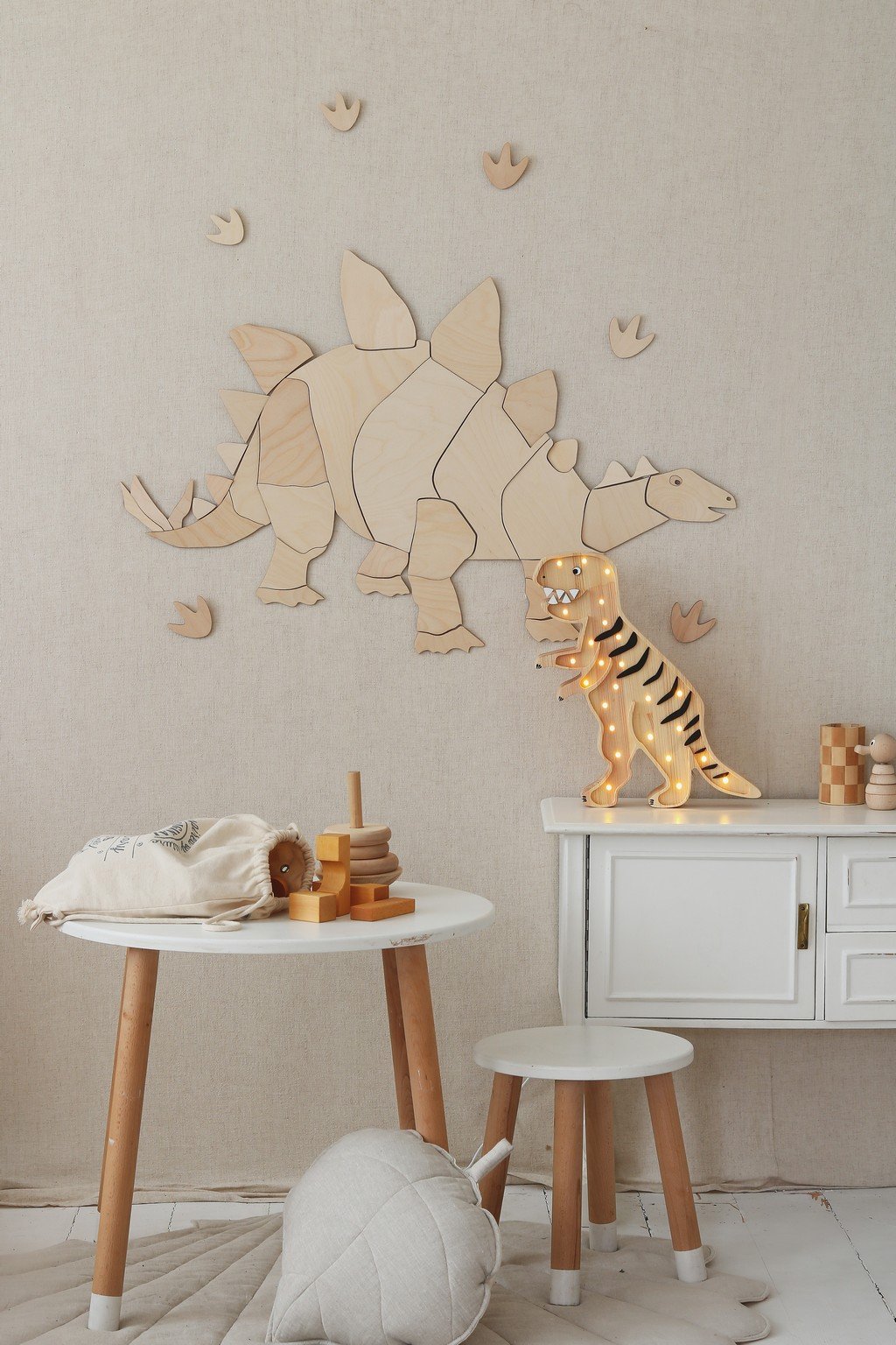 6. Wooden stegosaurus wall decoration with puzzle design above white cabinet and toys