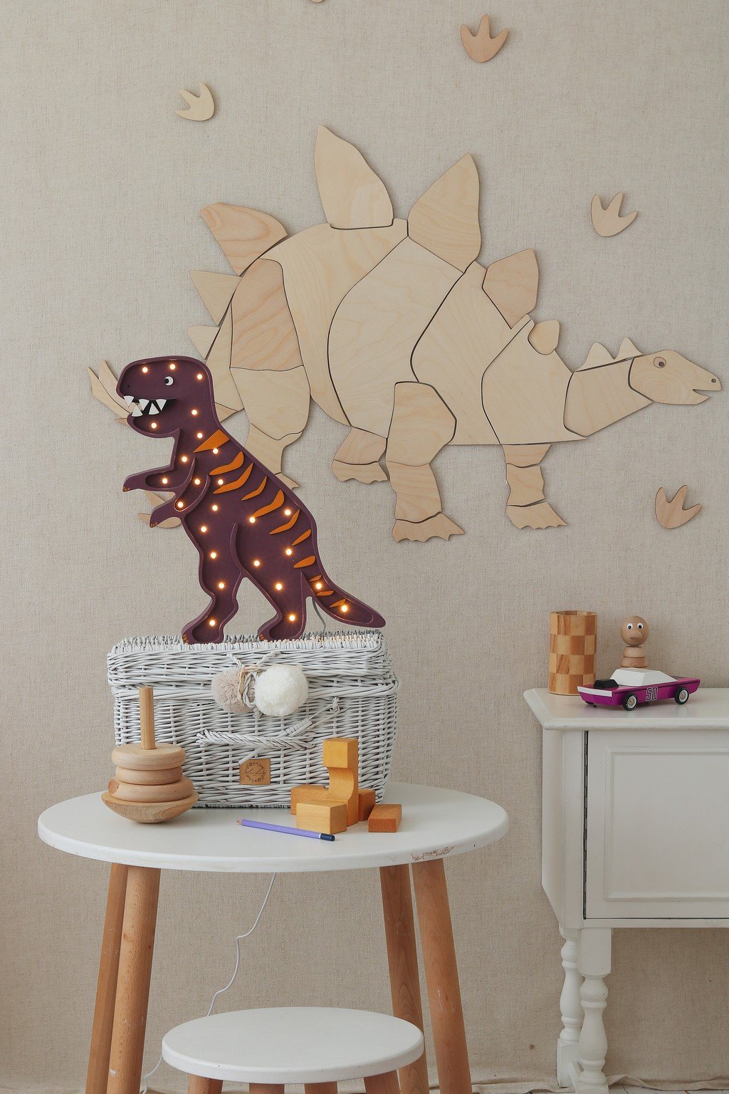 4. Wooden stegosaurus wall decoration with puzzle design above wicker basket and toys