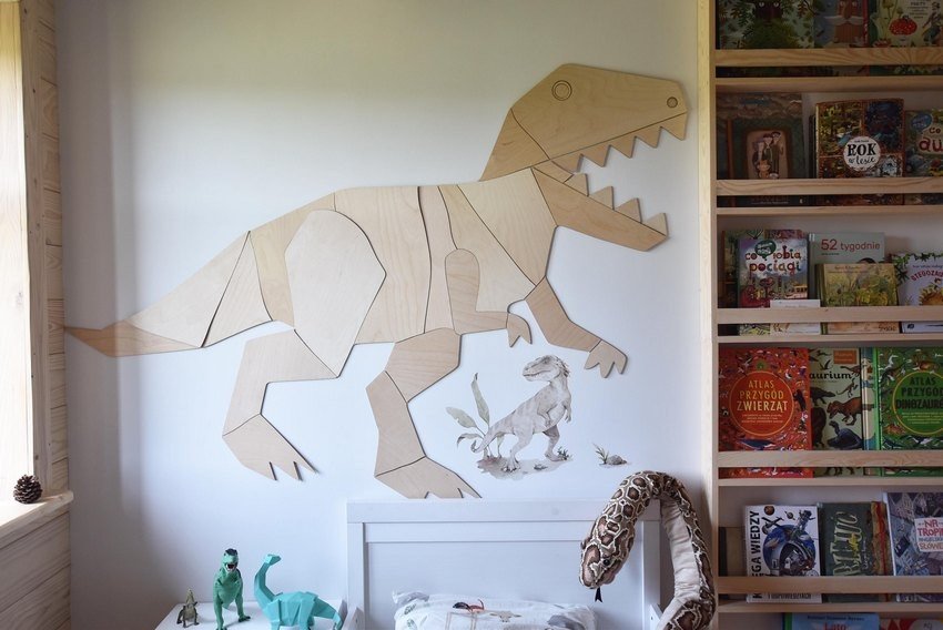6. Wooden T-Rex wall decoration in child's room with bed and bookshelf, creating a fun dinosaur theme