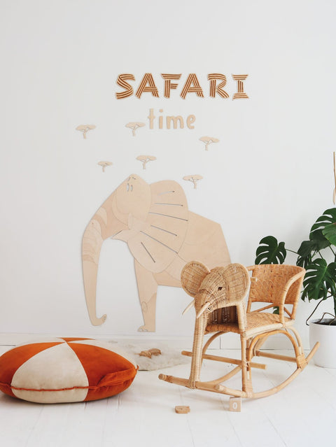 2. Safari-themed room with wooden elephant wall decoration, wicker rocking chair, and orange cushion
