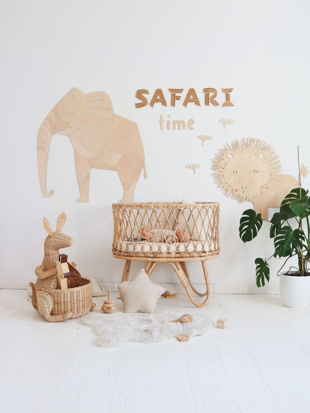 6. Safari-themed nursery with wooden elephant and lion wall decorations, wicker crib, and toys