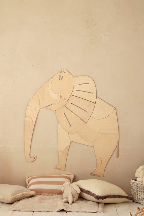 3. Wooden elephant wall decoration above cushions in child's room, natural tones