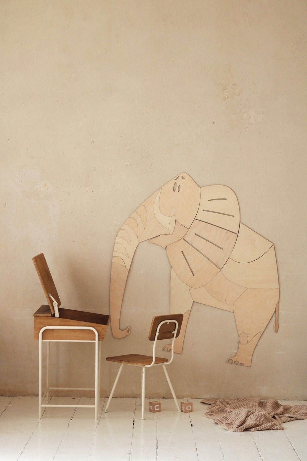 1. Wooden elephant wall decoration in child's room with desk and chair, natural setting