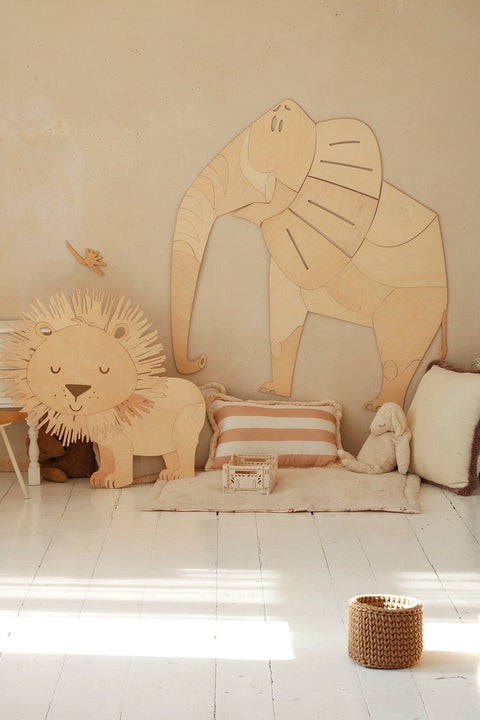 4. Wooden elephant and lion wall decorations in child's room with cushions and toys