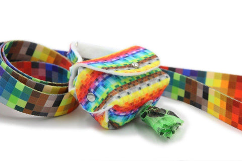 1. Colorful pixel-patterned dog waste bag dispenser with matching leash, featuring a metal eyelet for easy bag access, shown in a close-up view.