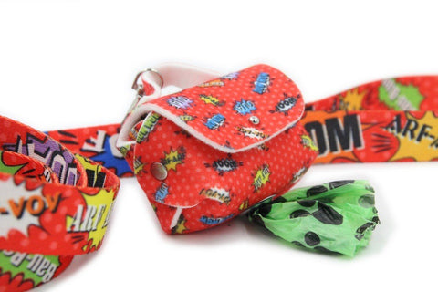 1. Red graffiti-patterned dog waste bag dispenser with green bag partially pulled out, attached to matching leash