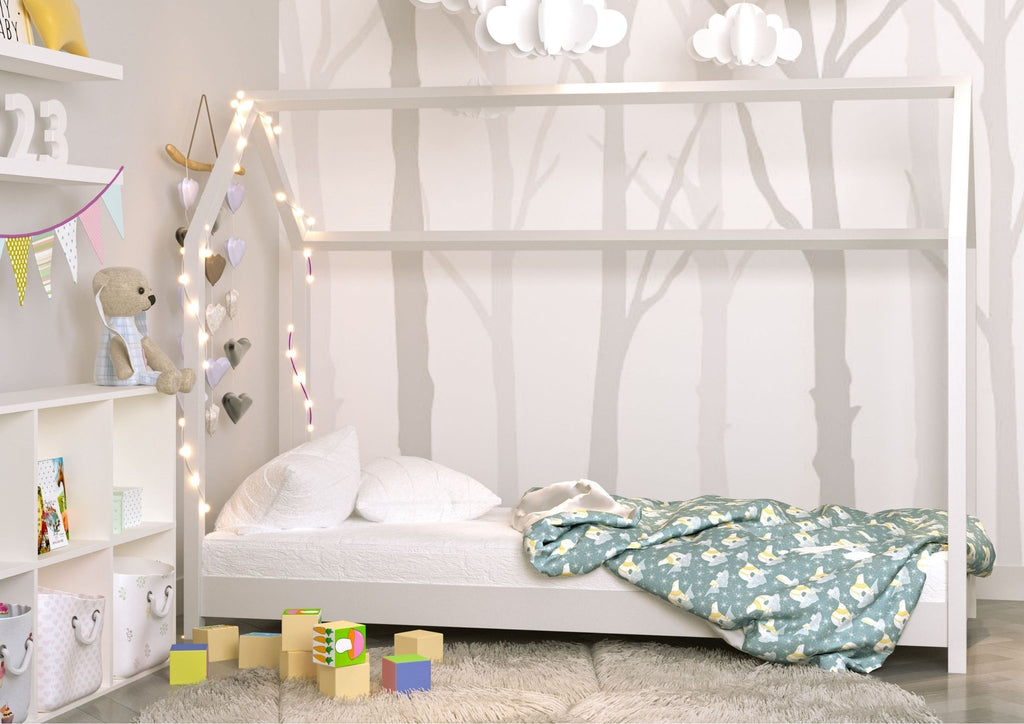 1. White house-shaped bed in a children's room, adorned with heart lights and surrounded by toys and a soft rug