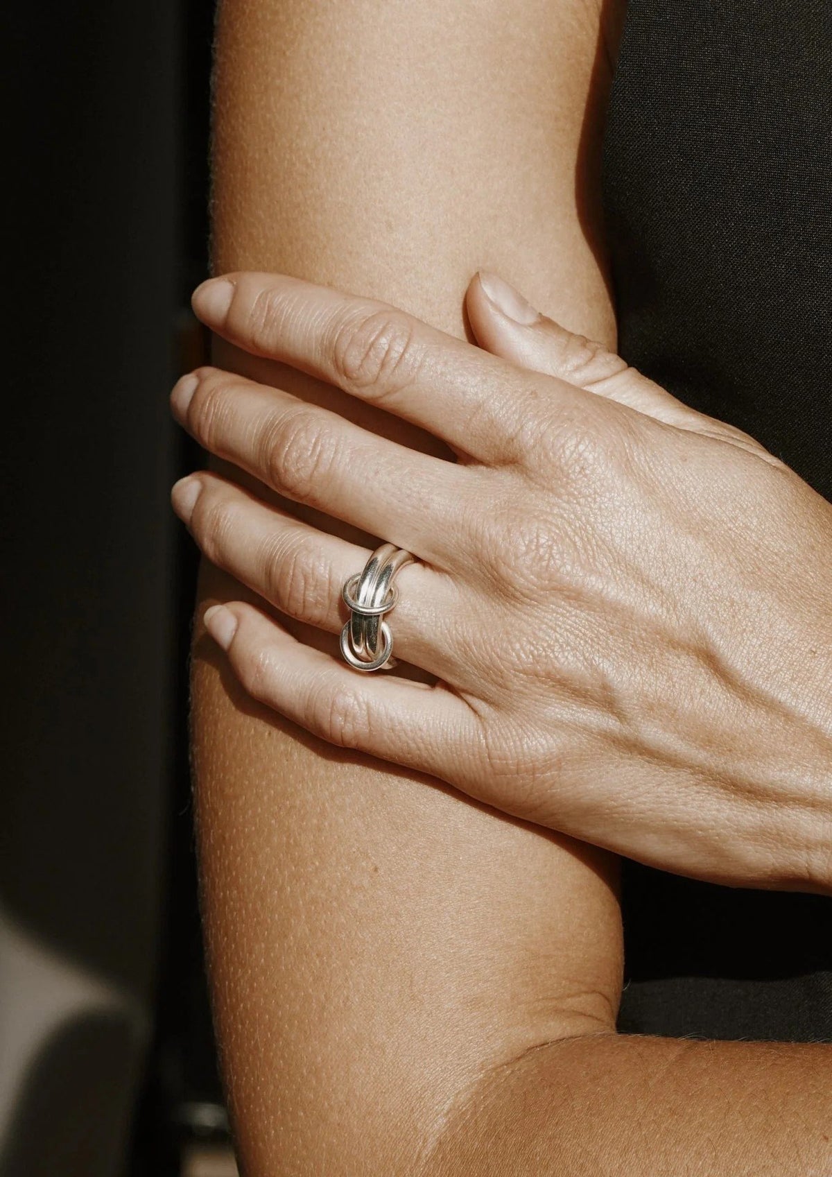 5. Close-up of woman's hand wearing NO MORE double ring in silver, highlighting the handcrafted design