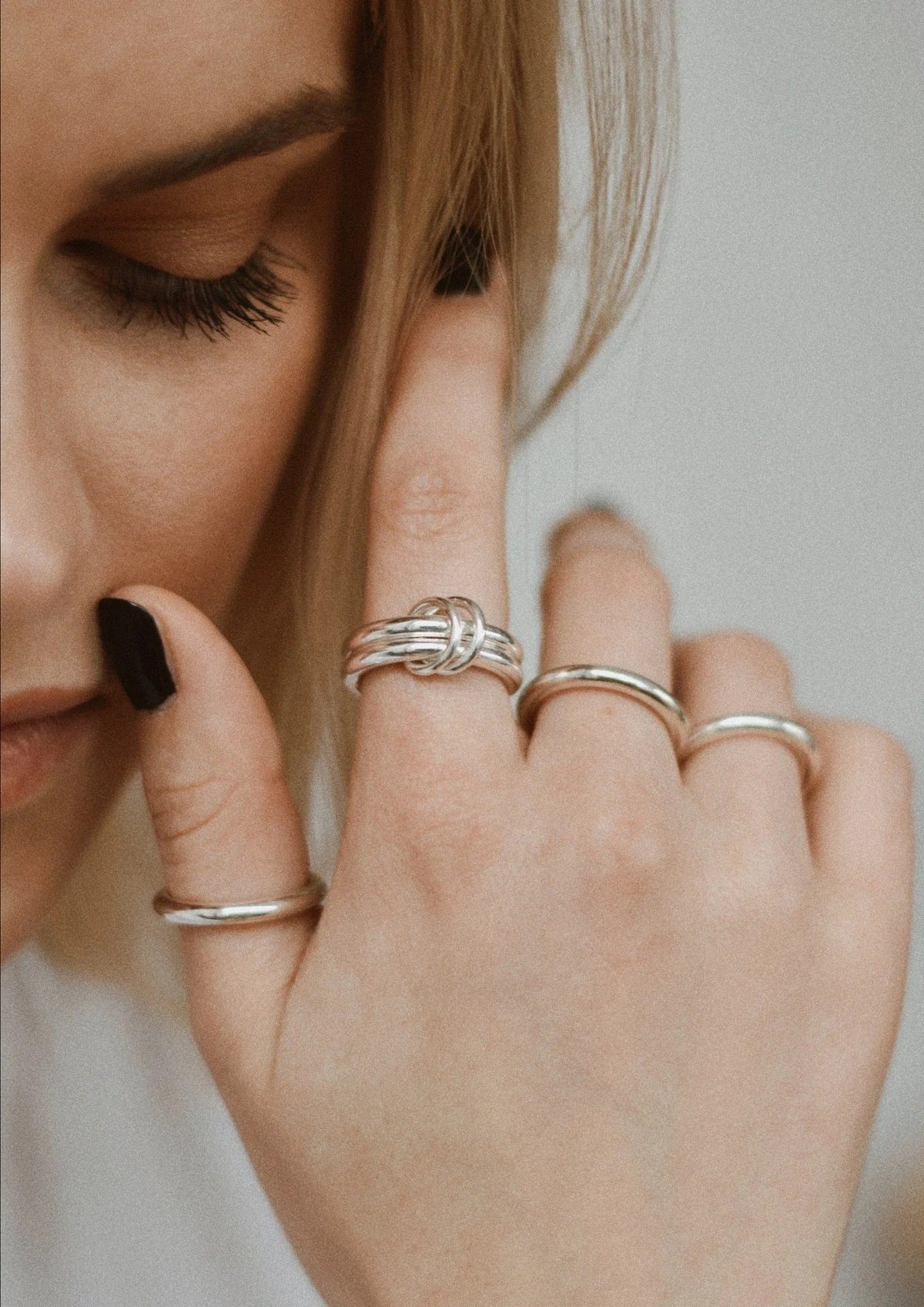 1. Woman wearing NO MORE double ring in silver, styled with other rings for a chic look