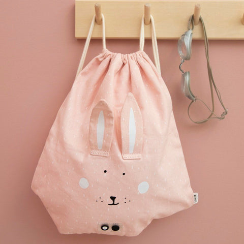4. Pink rabbit-themed drawstring bag hanging on wooden hooks with goggles