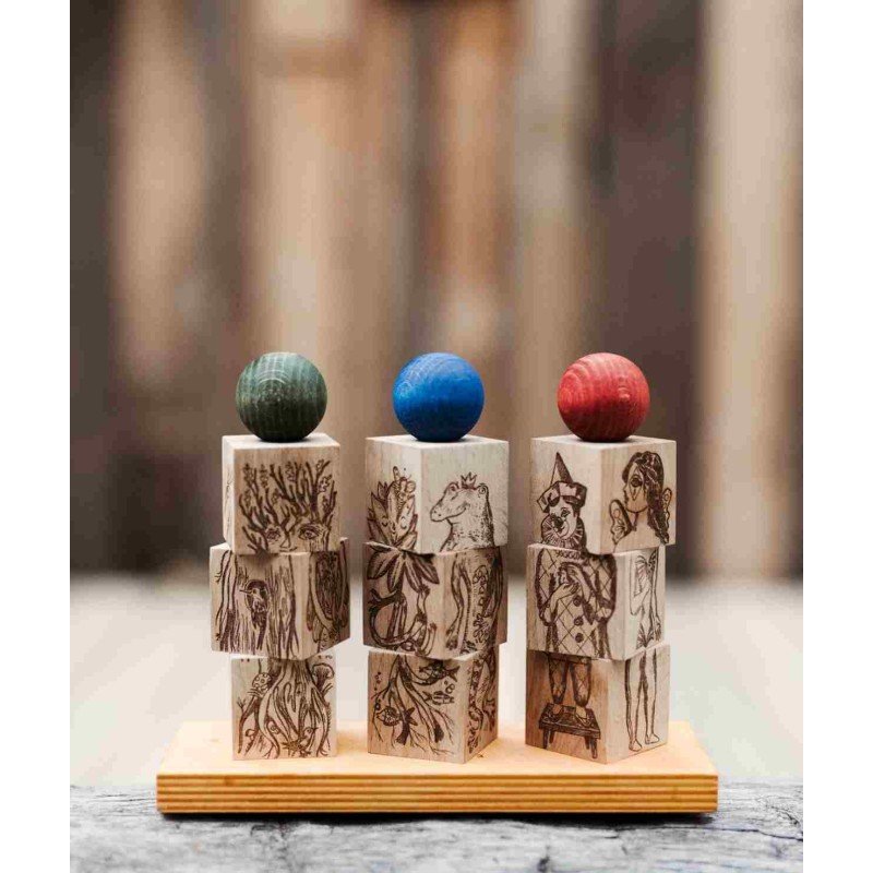 2. Wooden Story Dreamland Spinner Puzzle with engraved blocks and colorful spheres on a wooden base in a rustic setting