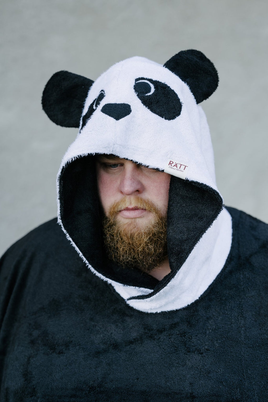 4. Close-up of RÄTT unisex bamboo terry poncho hood with panda face design, worn by a man