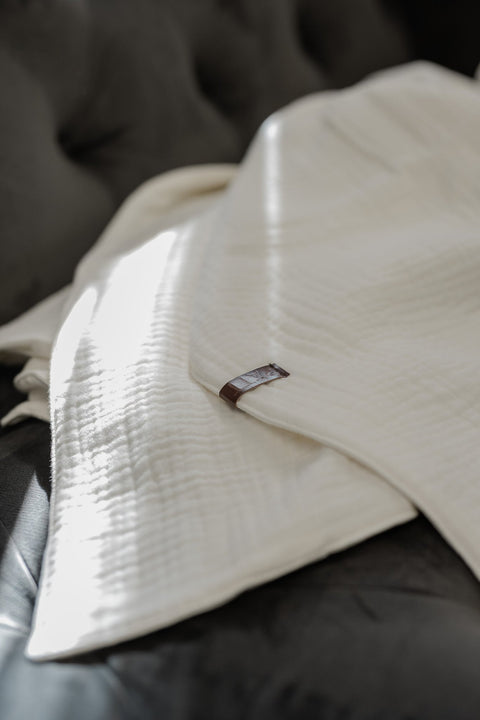 2. Close-up of RÄTT ivory white muslin cotton blanket highlighting the four-layer weave and soft texture