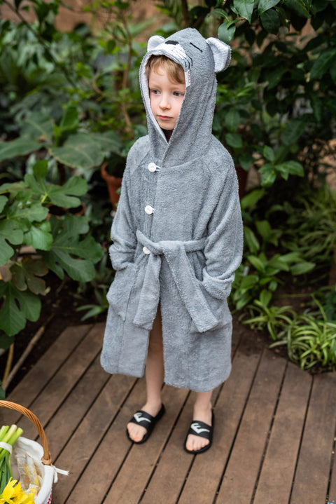 4. Boy wearing grey RÄTT CAT Bamboo Terry Bathrobe with hood and pockets, standing on wooden deck