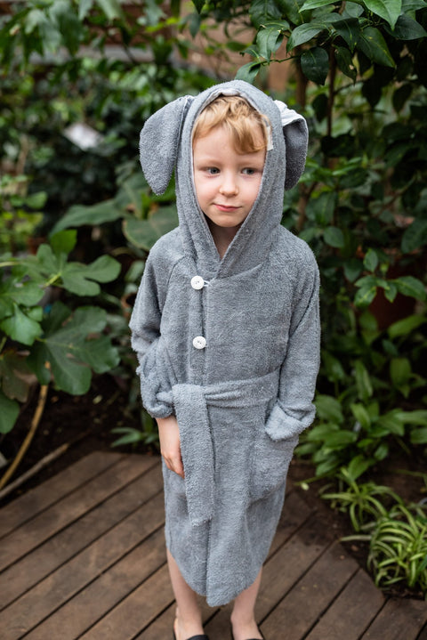 1. Toddler wearing RÄTT bamboo terry bathrobe BUNNY with hood and belt, shown in garden setting