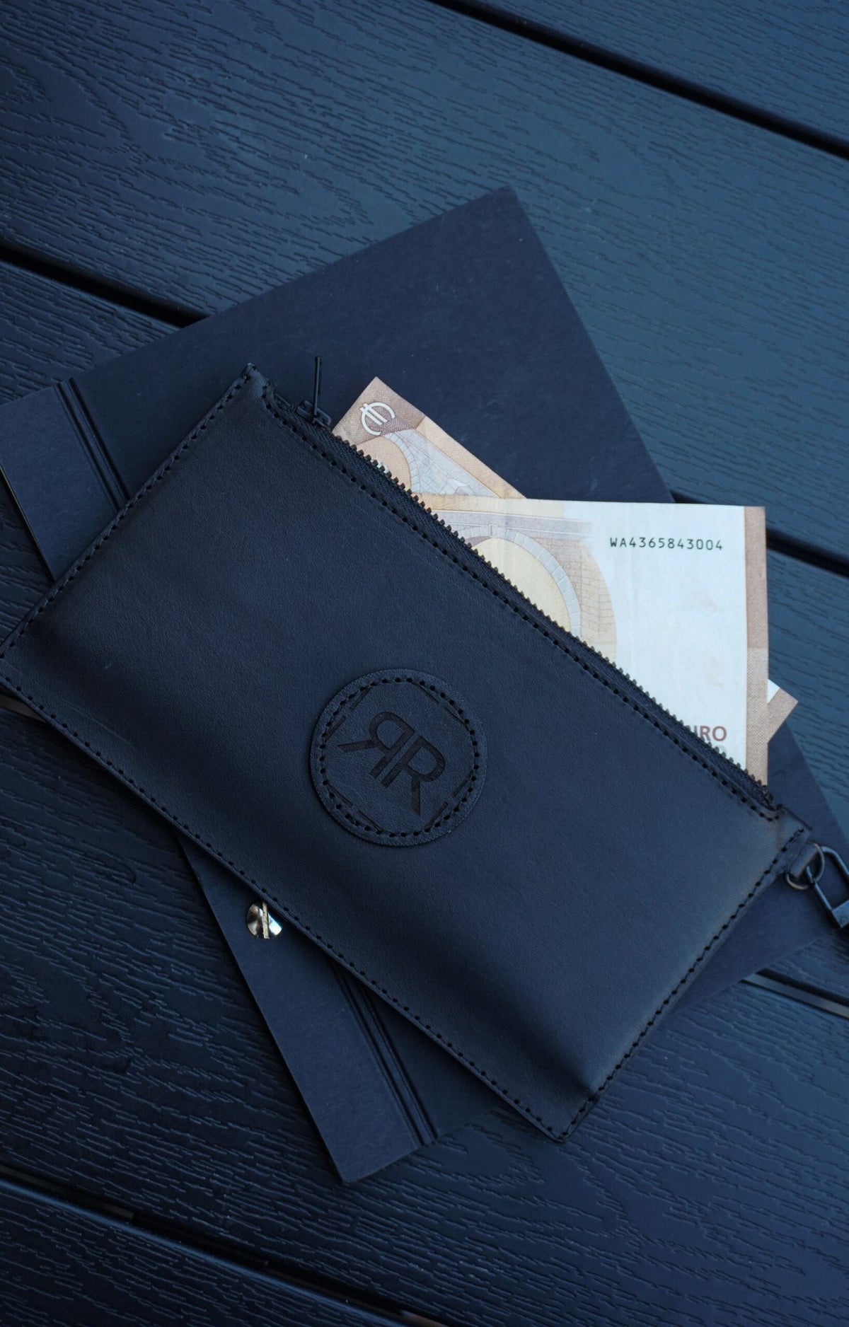 6. Close-up of RR leather wristlet wallet with cash and notebook, showcasing spacious compartments