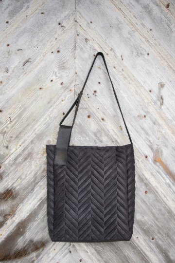 2. Mixed material handbag by RR with chevron pattern, shown hanging against rustic wooden background