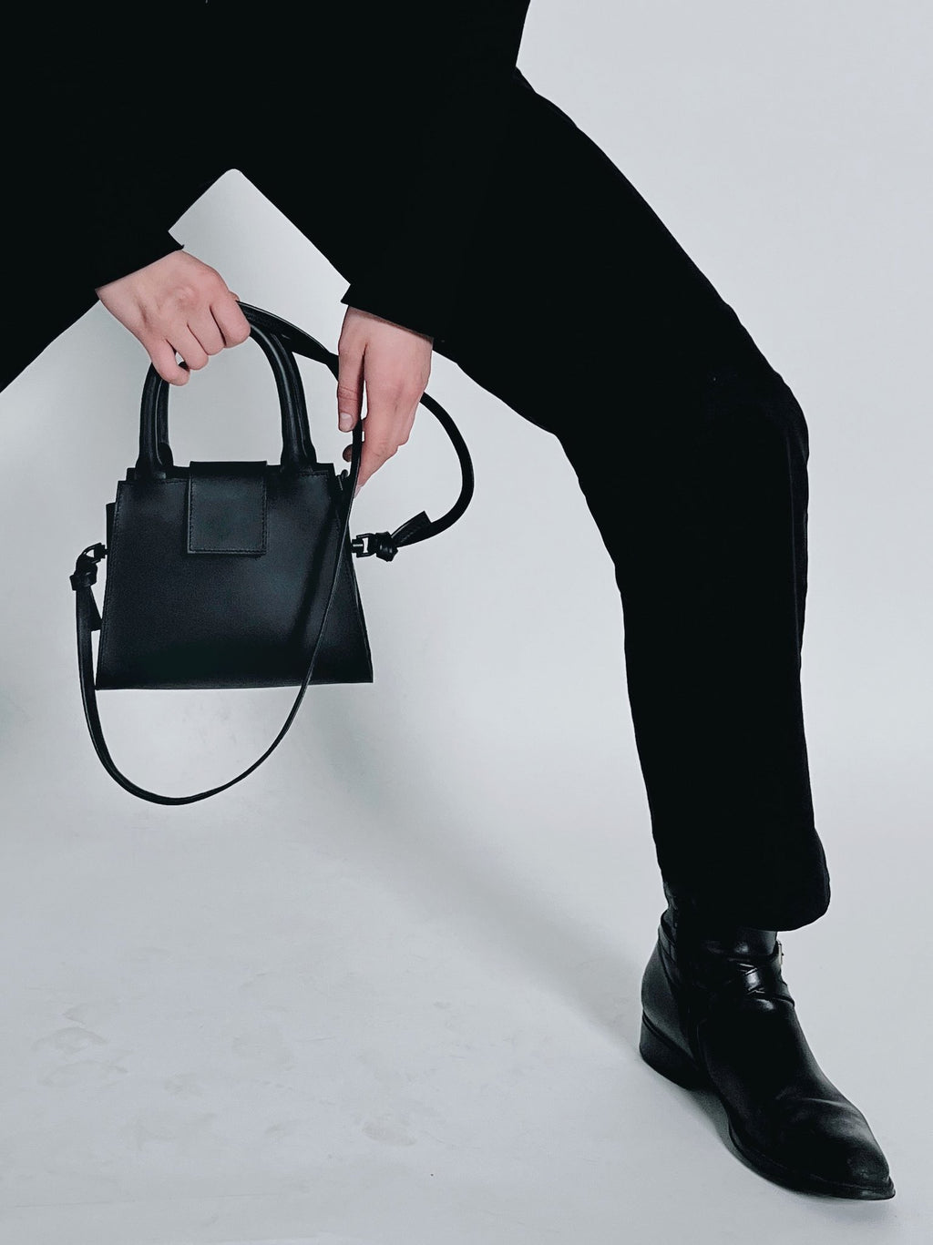 1. Women's mini leather handbag by RR, styled with black outfit, showcasing detachable strap and magnetic closure