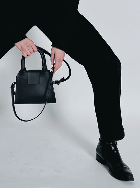1. Women's mini leather handbag by RR, styled with black outfit, showcasing detachable strap and magnetic closure