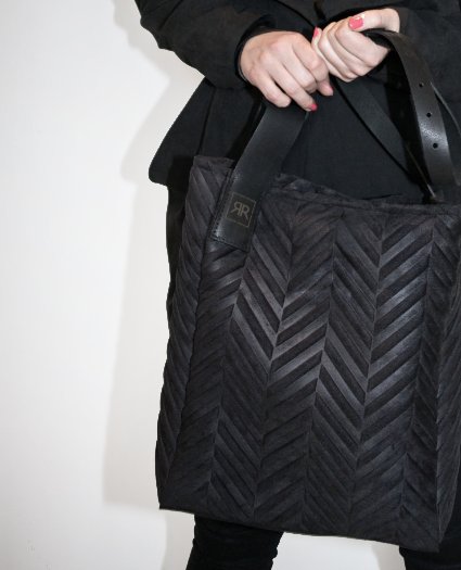 1. Women's mixed material handbag by RR with genuine leather strap, held by model in lifestyle setting