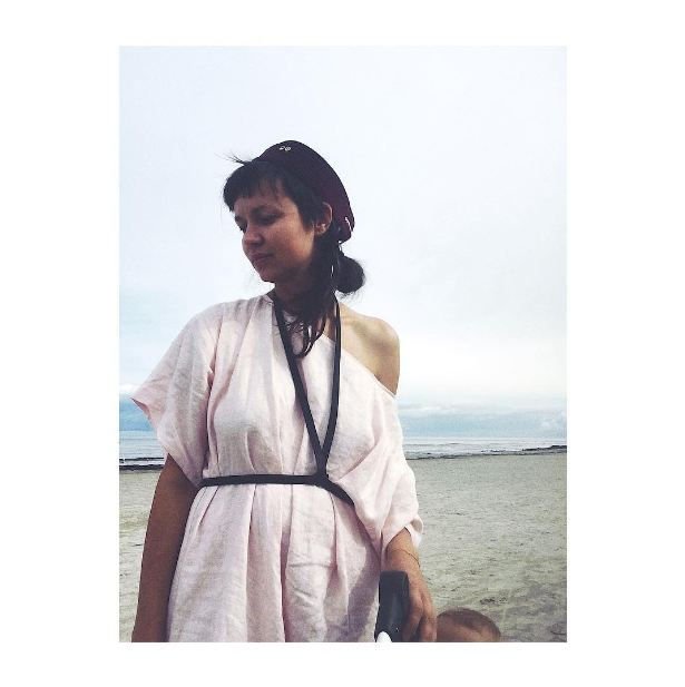 1. Women's black leather body harness by RR styled with red pants and black top, outdoor setting