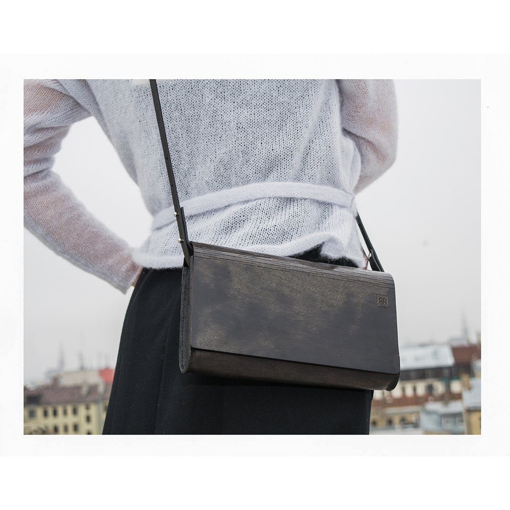 4. Large glossy wood clutch by RR worn crossbody with a white top, urban background