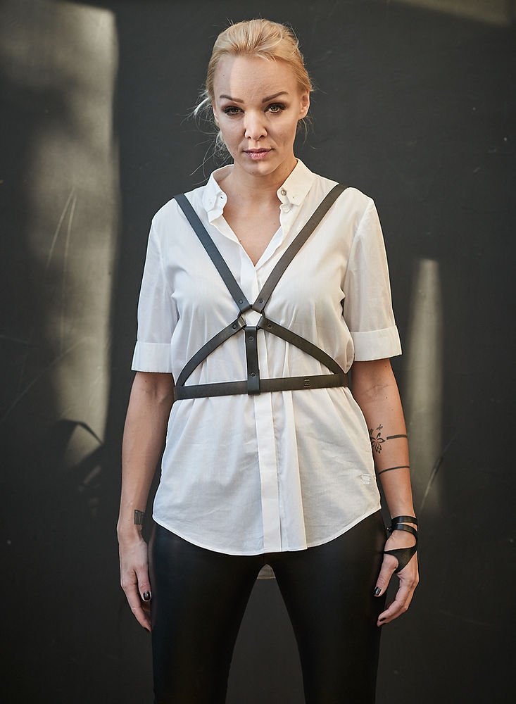 1. Women's black leather body harness by RR worn over white shirt, front view