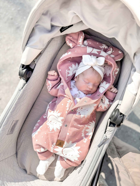 1. Baby sleeping in stroller wearing Zezuzulla pink suns eared jumpsuit with white bow headband