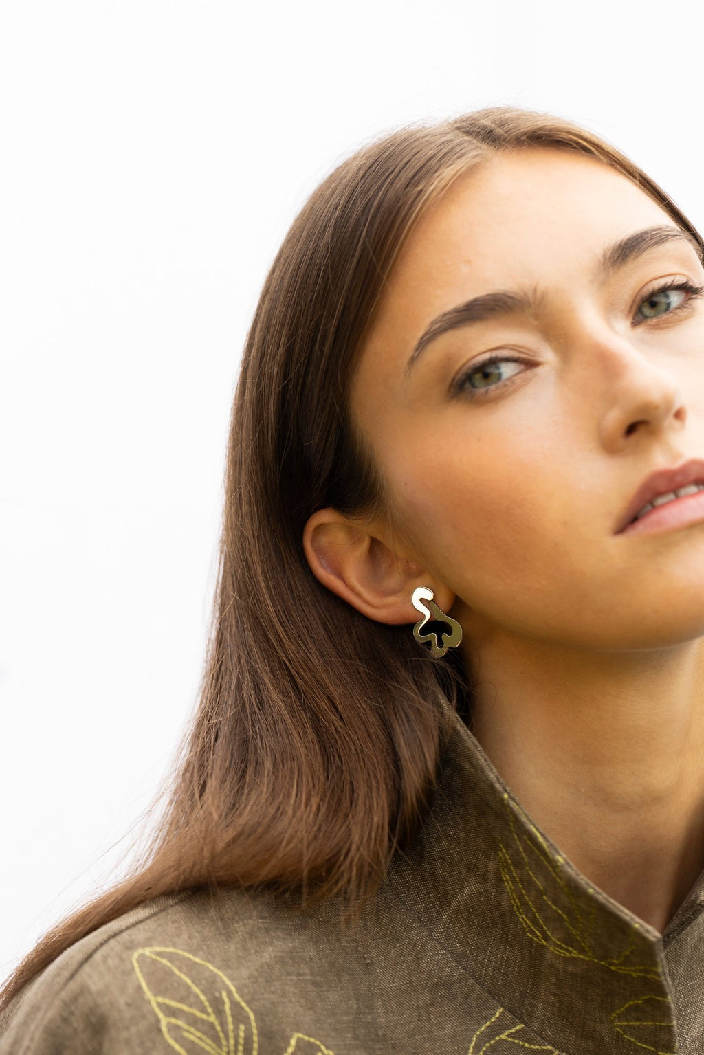 1. Woman with head tilted wearing Lentsius Folia Bold earrings, emphasizing stainless steel elegance