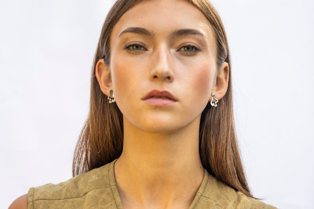 1. Woman wearing Lentsius Folia Mini earrings with polished finish, facing forward