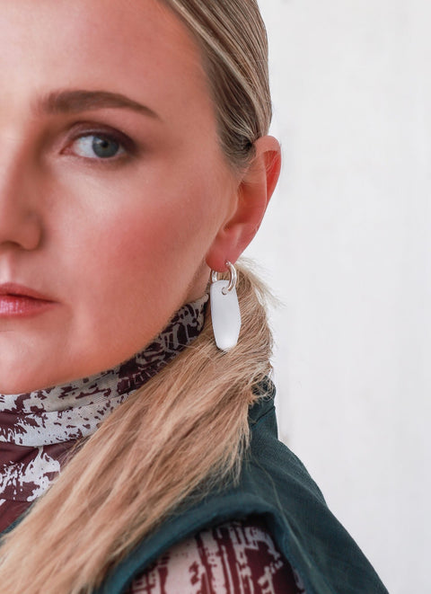 1. Woman wearing Lisa Kroeber Jewellery Mix&Match HOOPS with silver plate, showcasing customizable design in lifestyle setting