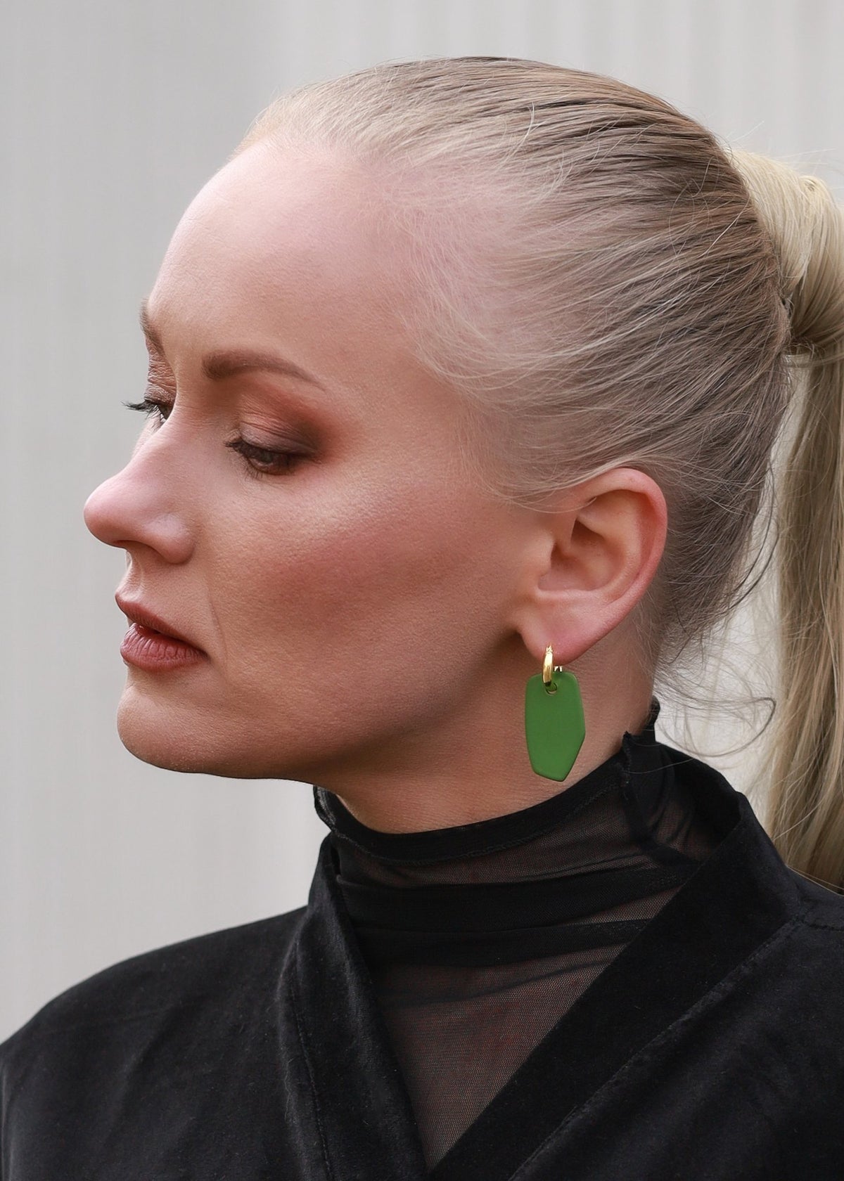 1. Woman wearing Lisa Kroeber Jewellery Earrings Mix&Match PLATES in white, styled with a patterned top