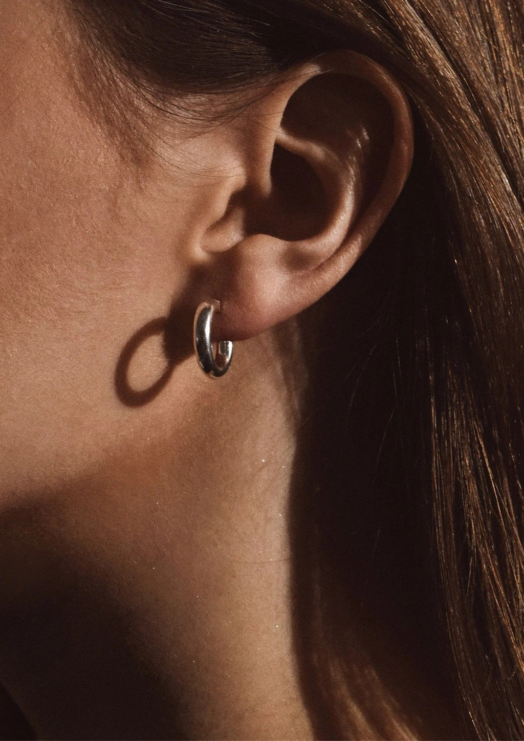 1. Women's Ella Hoops Earrings in silver worn by model, showcasing elegant design and lightweight fit