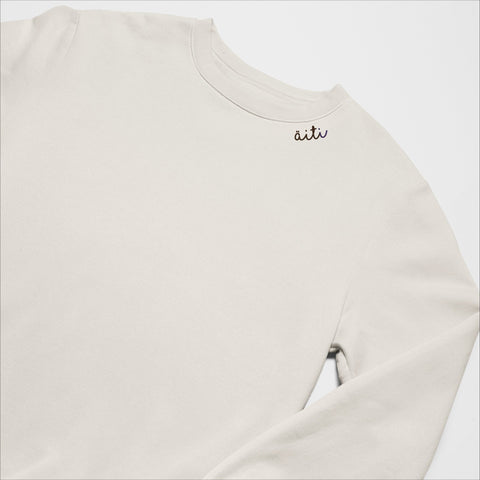 4. Unisex beige Äiti sweatshirt with embroidered collar, laid flat in studio