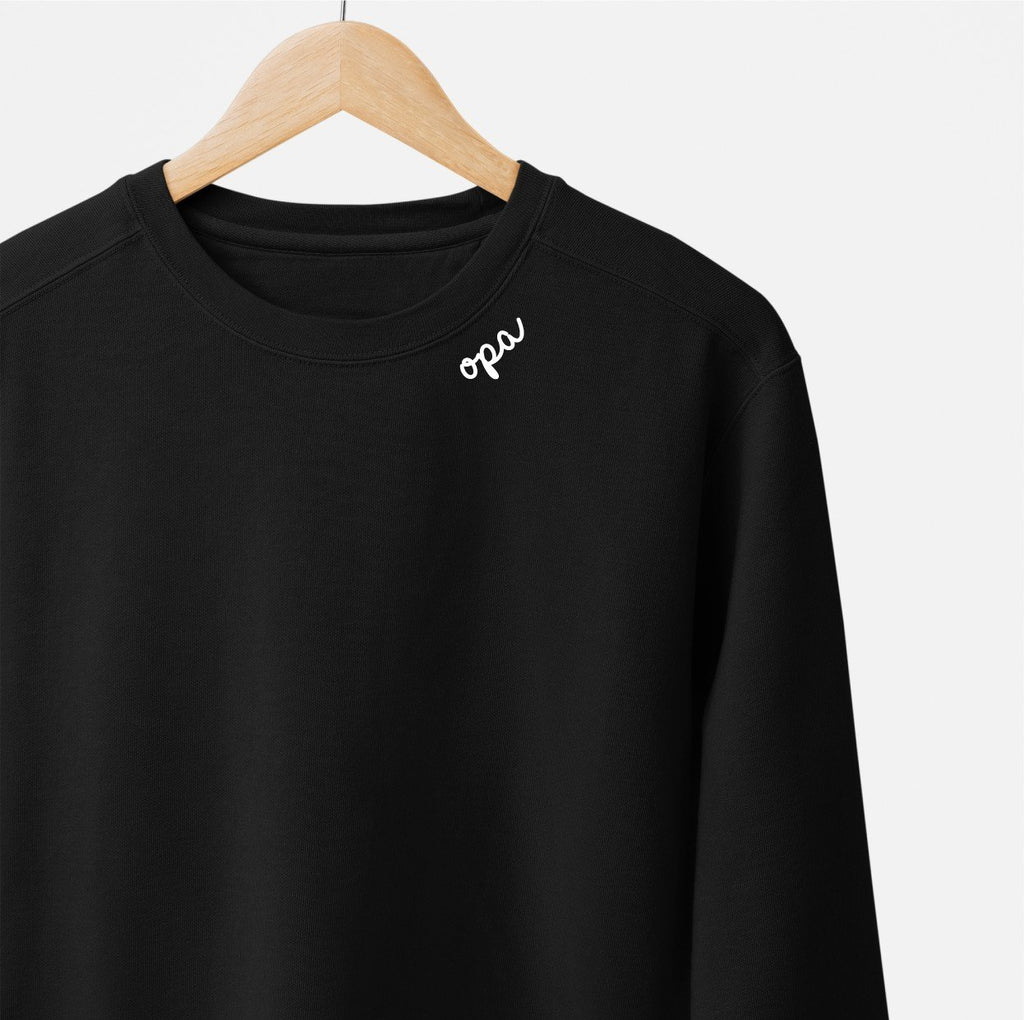 3. Black unisex sweatshirt with white 'opa' embroidery on collar hanging on wooden hanger