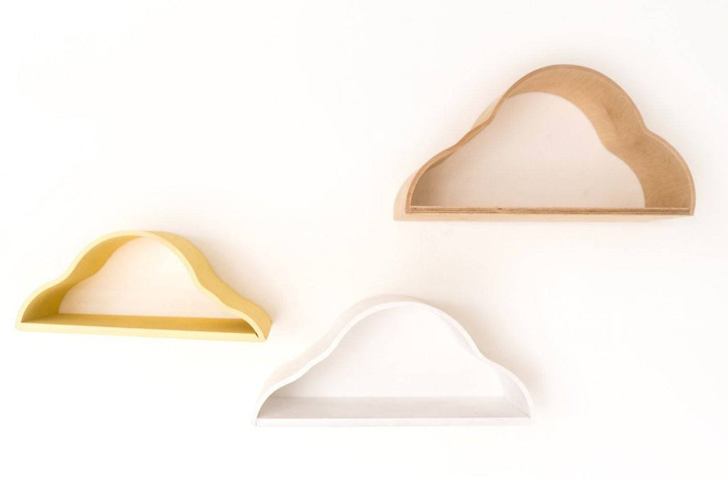 3. Close-up of three cloud-shaped floating shelves in white, yellow, and natural wood colors on a white wall.