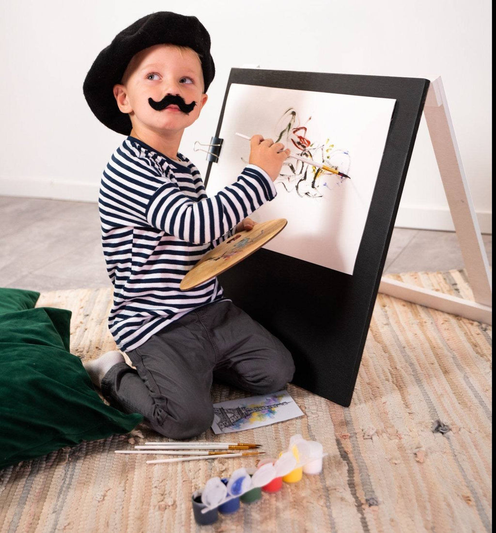 4. Child in striped shirt and beret painting on Ewart Woods black wooden chalkboard easel with paint palette