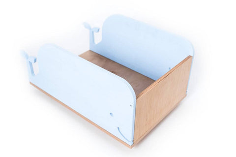 2. Blue whale-shaped wooden toy box on wheels with plywood base in studio setting