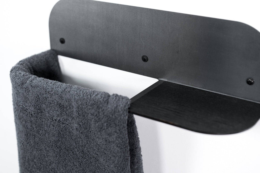 2. Steel and wood towel rack with black finish, holding a dark towel, mounted on a white wall