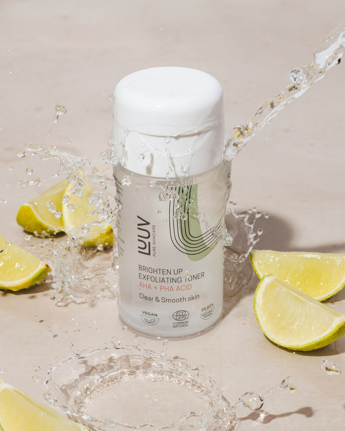 1. LUUV Exfoliating Face Toner with AHA and PHA Acid, 120 ml, surrounded by lime slices and splashing water on a beige surface