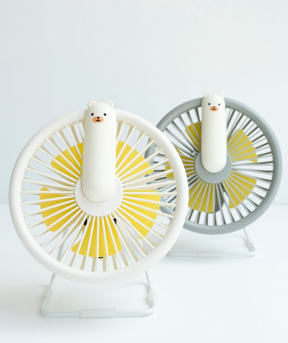 4. Flat lay of two Little Bear Fan Lamps in grey and white with yellow blades on white surface