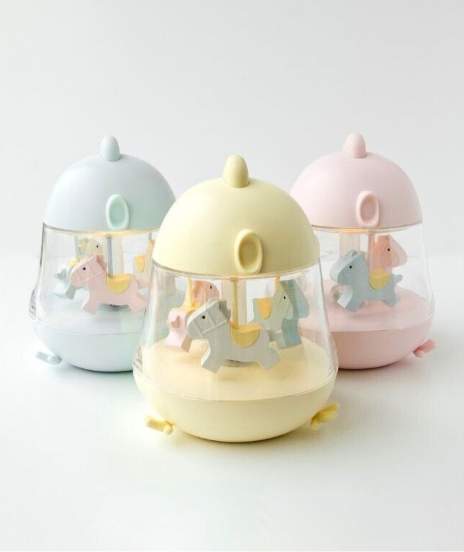 4. Flat lay of three Rabbit & Friends lamps in blue, yellow, and pink with carousel design